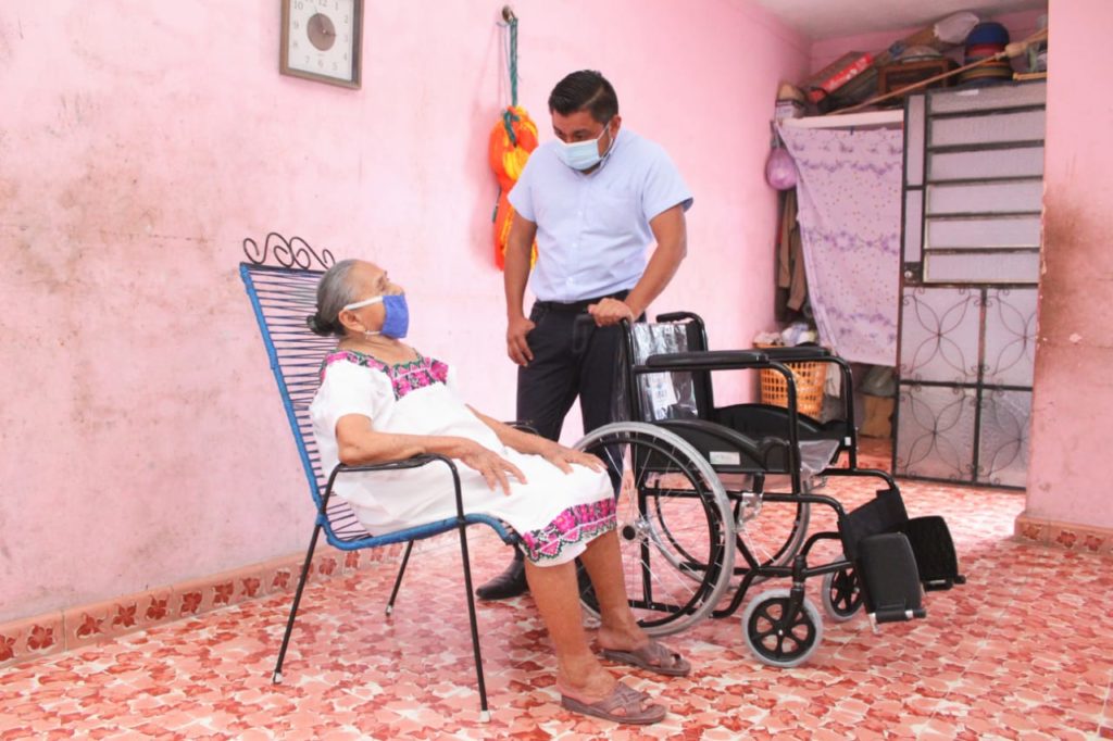 La contingencia del COVID-19 aún no termina, por ello, el alcalde Freddy Ruz Guzmán sigue apoyando a la gente que más lo necesita, en esta ocasión le llevó hasta a la puerta de su casa una silla de ruedas a doña Concepción Ek, vecina de la colonia Centro, quien ha perdido la visión parcialmente y tiene problemas para caminar a causa de la diabetes que padece. Doña Concepción la recibió muy contenta y emocionada porque esta silla le permitirá a sus familiares trasladarla con mayor facilidad, ya sea dentro de su casa o cuando le avisen que puede acudir nuevamente a sus consultas. “Tengo el compromiso de seguir ayudando a las personas más vulnerables, puesto que un aparato ortopédico les cambia la vida no sólo a los beneficiarios sino a la familia completa al permitirles tener una mejor calidad de vida”, afirmó el primer edil.