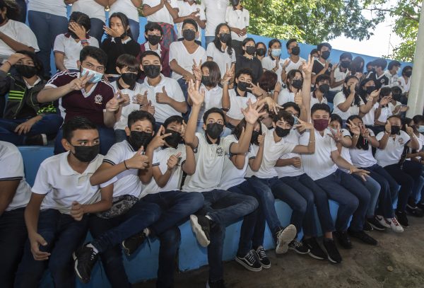 Gracias al trabajo coordinado entre las autoridades de salud, educativas, escolares y las familias, este 29 de agosto comienzan las clases de manera presencial en las escuelas públicas y en gran parte de las instituciones particulares de Educación Básica y Media Superior del Estado. En atención a la instrucción del gobernador Mauricio Vila Dosal, de priorizar la salud de la comunidad educativa, el titular de la Secretaría de Educación del Gobierno del Estado, Liborio Vidal Aguilar, informó que en el Protocolo para el Regreso Seguro a Clases del Ciclo Escolar 2022- 2023 se pone énfasis en el fortalecimiento de las medidas preventivas generales y los tres filtros de corresponsabilidad: el más importante, el de casa para detectar algún signo o síntoma de Covid-19, el segundo a la entrada de la escuela y el tercero en el aula. El documento, alineado a las indicaciones de la Secretaría de Educación Pública (SEP), establece que en todas las entidades federativas se prevé el 100 por ciento de presencialidad, considerando que el personal docente, directivo y de apoyo a la educación cuenta esquema de vacunación completo, incluyendo el refuerzo de acuerdo con su edad, lo que contribuye a disminuir el riesgo de contagio. La autoridad federal recomienda la vacunación a partir de los cinco años, con prioridad de quienes viven con comorbilidades o condiciones preexistentes, para garantizar que ningún estudiante se quede sin recibir la vacuna. De esta manera la inmunización fortalece las actividades esenciales, como asistir a la escuela, pues es importante para el desarrollo psicosocial y educativo durante la infancia y la adolescencia. En este contexto sanitario de contagios a la baja, semáforo verde y población infantil y adolescente vacunada, se espera que 439 mil 897 estudiantes de Educación Básica y 89 mil 160 de Educación Media Superior de escuelas públicas y privadas, vuelvan a sus aulas. El documento actualizado del protocolo, se encuentra alojado en el https://regresoaclases.yucatan.gob.mx/ para su consulta y descarga. Dentro de los puntos destacados para este nuevo periodo se encuentran: modalidad de clases cien por ciento presencial; los recreos o recesos ya no serán escalonados, sino simultáneos y con consumo de alimentos y se mantiene la medida de actuación ante un caso de COVID-19 que indica que, si un estudiante o personal educativo es diagnosticado con el virus, se retira durante siete días naturales y las clases continúan de manera habitual. El secretario de educación, Liborio Vidal Aguilar reconoció el esfuerzo y compromiso del magisterio yucateco y reiteró la disposición de la dependencia de atender a los colectivos escolares con una política de puertas abiertas enfocada en elevar la calidad educativa del estado. Por su parte, la directora general de Educación Básica, Linda Basto Ávila destacó el papel del Comité Participativo de Salud Escolar para cuidar la adecuada aplicación del protocolo, que permitió desde el ciclo pasado un entorno seguro y sin brotes de contagio importantes. Recordó que este año se mantendrá y fortalecerá el acompañamiento socioemocional del personal escolar y los estudiantes, luego de los periodos de confinamiento y clases a distancia.
